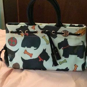 A white handbags with playful dogs on it.